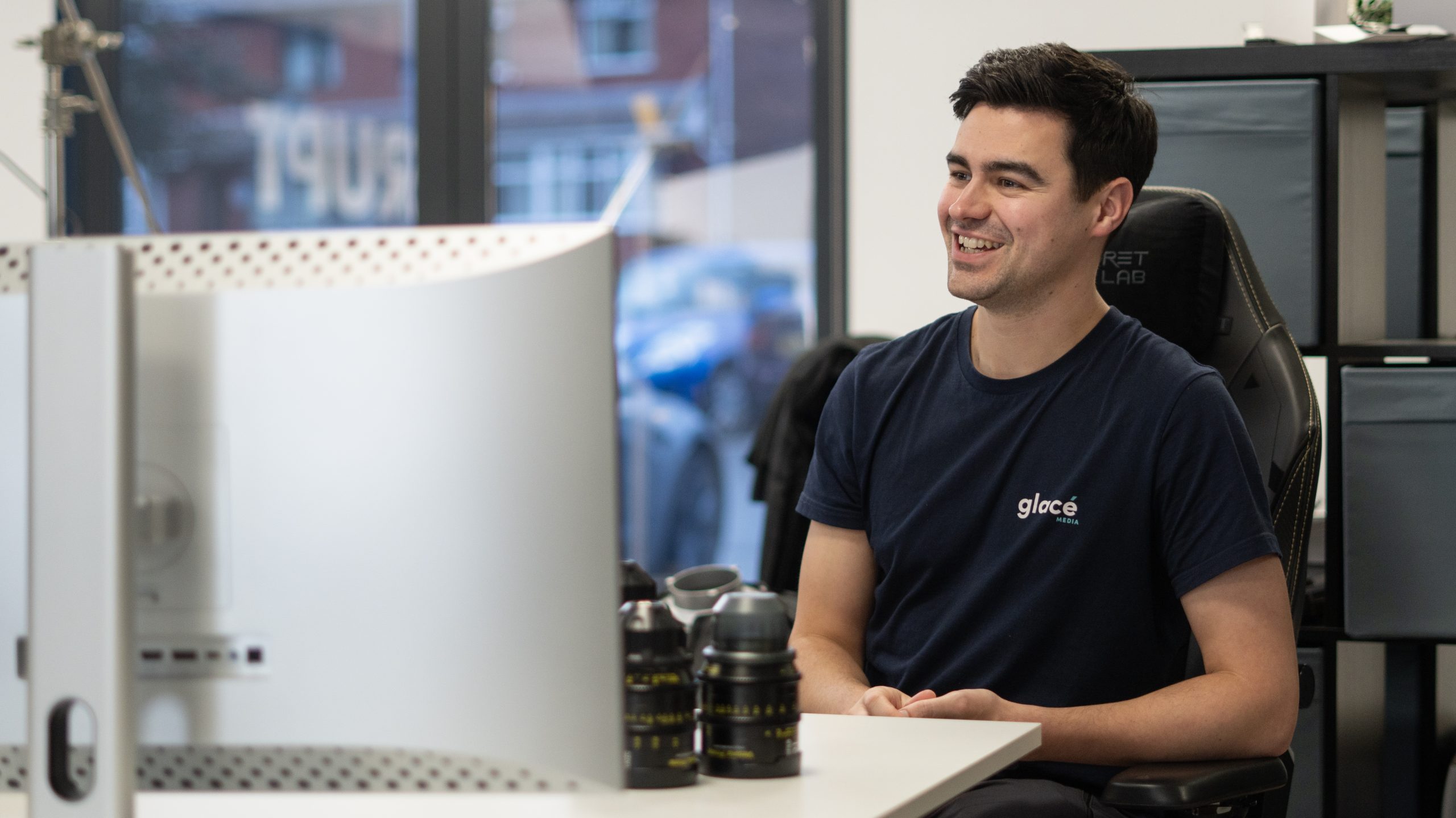 Managing Director of Glacé Media, Marcus Johnson sat in an office chair smiling as a part of a case study video production shoot